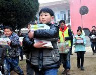 2016年1月8日下午,在駐馬店市汝南縣三門閘街道大新莊小學校院內，駐馬店市陽光助學協(xié)會負責人及志愿者、大新莊學校師生、學生家長歡聚一堂，舉行了“陽光助學愛心圖書室”捐贈儀式。圖為學生和志愿者一起搬運新書