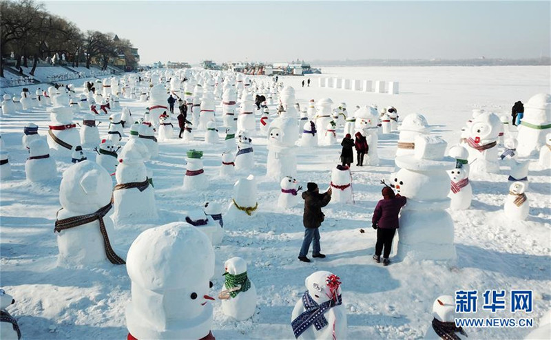 1月2日，市民、游客在雪人群中游玩觀賞（無(wú)人機(jī)拍攝）。2019個(gè)各式各樣的雪人，近日在冰城哈爾濱市的松花江畔亮相，引來(lái)眾多市民游客游玩觀賞。新華社記者 王建威 攝